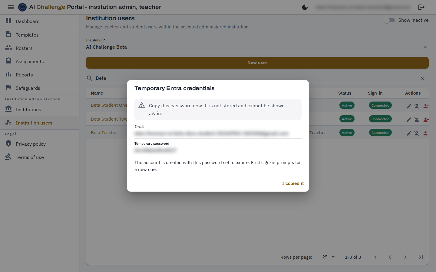 The Temporary Entra credentials dialog, headed by a warning that the password is not stored and cannot be shown again, above a read-only email box and a read-only temporary password box, with an I copied it button beneath. Both the address and the password are blurred.